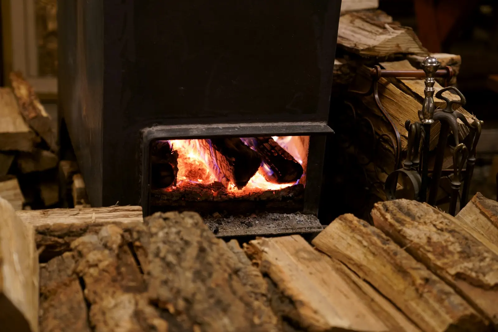 Wood stove with a fire and split firewood